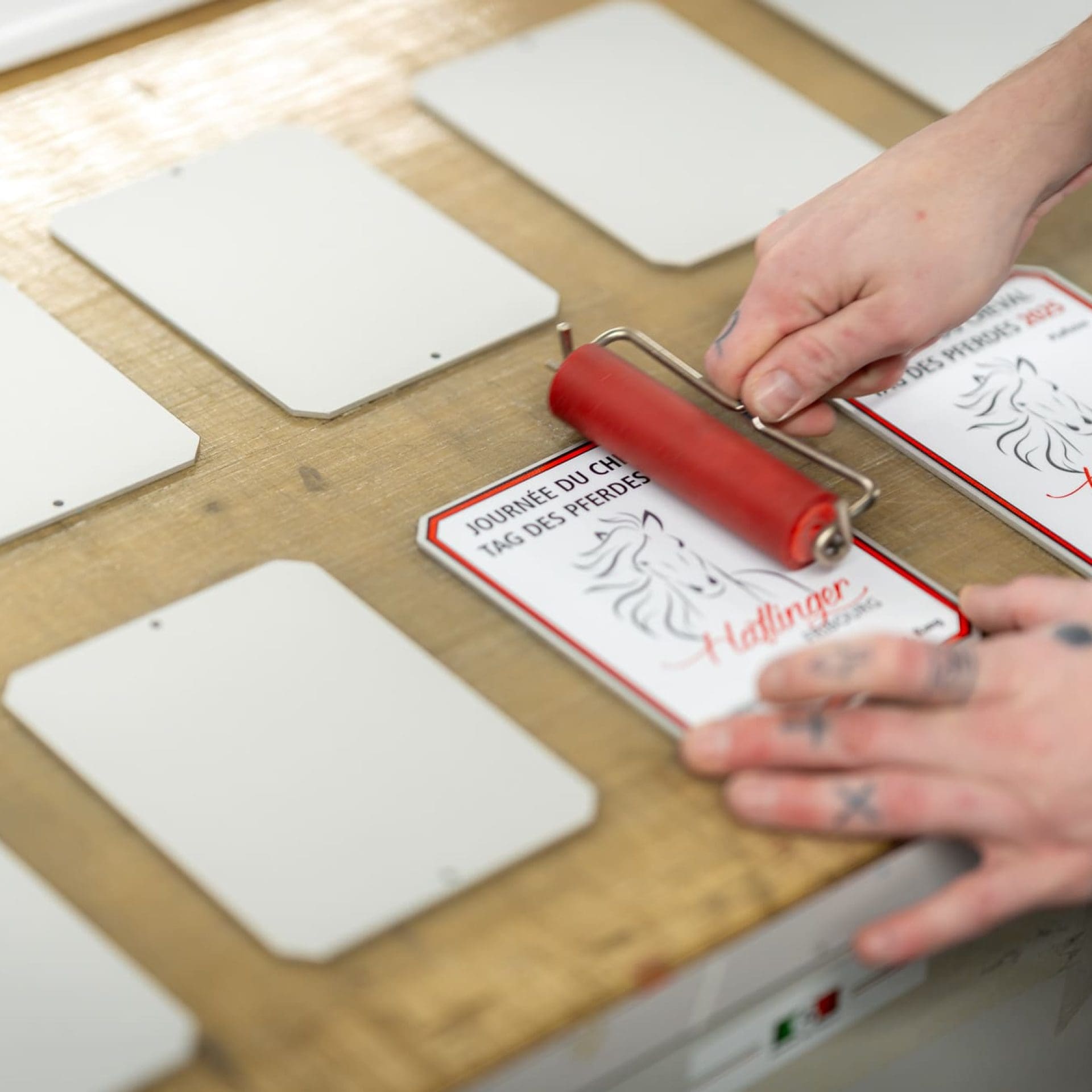 Produktion individueller Stallplaketten im Entlebucher Medienhaus Mitarbeiter des Entlebucher Medienhauses bei der Produktion individueller Stallplaketten – sorgfältige Gestaltung und hochwertige Verarbeitung in der hauseigenen Druckerei